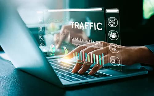 Hands on a laptop with traffic and conversion analytics overlaid above the keyboard